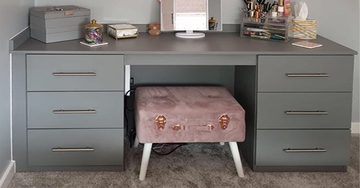 Fitted bedroom dressing table in a mid-grey matt finish with chrome handles.