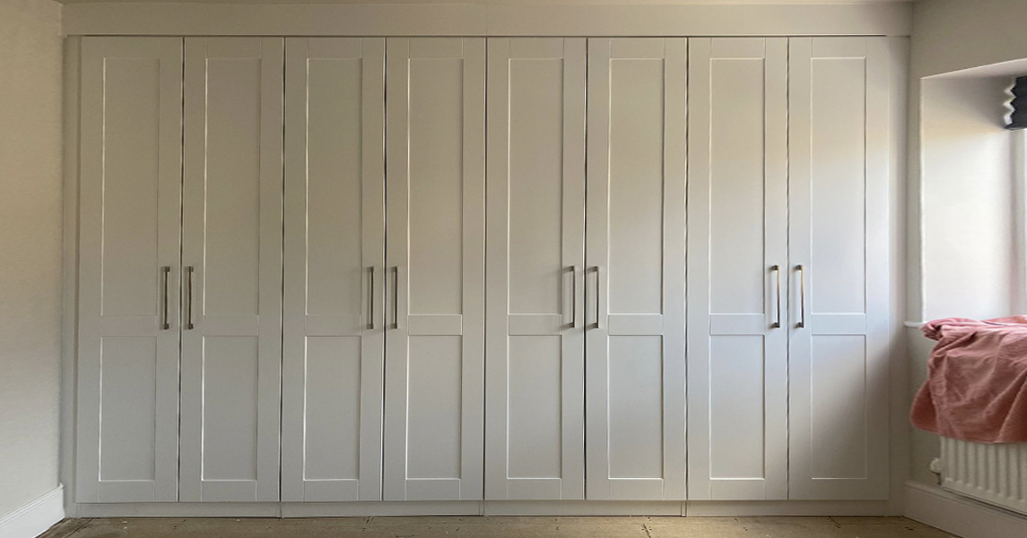 Ivory fitted wardrobes with shaker-style doors.