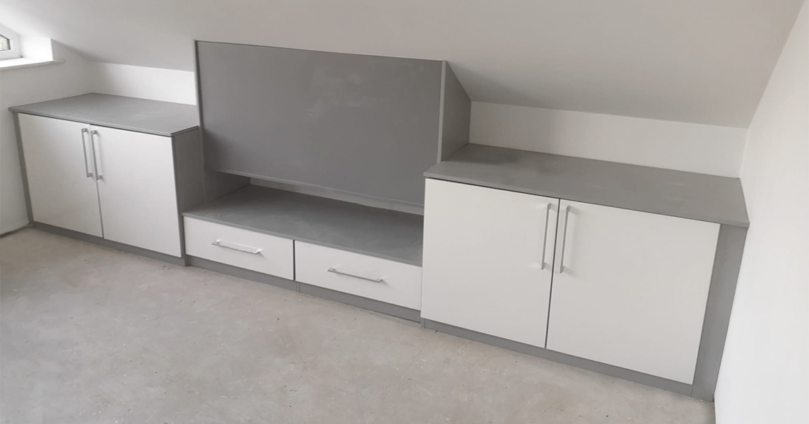 Fitted media unit a matt cream, grey finish and chrome handles.