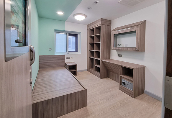 Antiligature bedroom furniture with integrated storage and desk